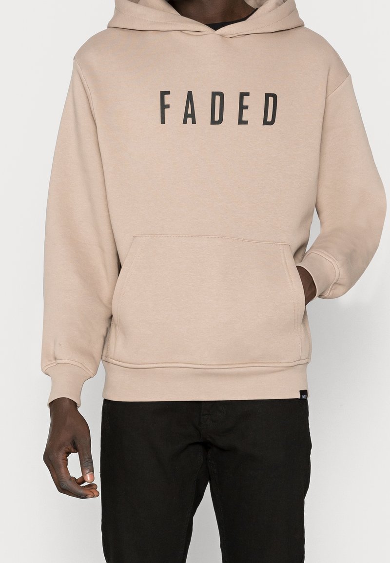 Felpa beige con una grande stampa nera "FADED" sul fronte, dotata di tasca a marsupio e polsini a coste. Realizzata in tessuto morbido.