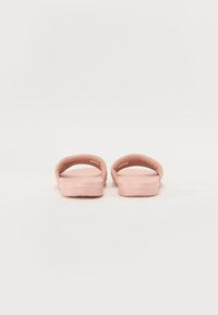 Rosa slip-on sandaler med en glatt gummi-overdel og flat såle. Minimalistisk design med åpen tå og fotseng med subtil tekstur.