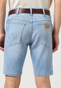 Lichtblauwe denim shorts met een rechte snit, afgewerkt met achterzakken met een zigzagsteek en een bruine leren merkpatch op de tailleband.