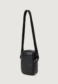 Melnas ādas crossbody soma ar teksturētu dimanta rakstu, ar rāvējslēdzēju un regulējamu siksnu. Gluda virsma ar sudraba akcentiem.