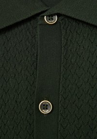 Polo de culoare verde închis, realizat dintr-un material tricotat texturat, cu guler și un buton cu margine aurie, inscripționat cu "REISS."