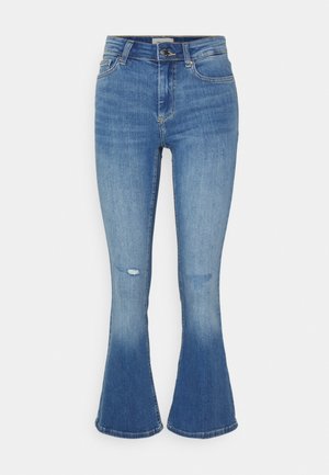 Jean bleu taille haute évasé avec légère usure sur les cuisses et délavage estompé.