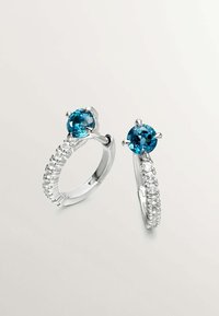 Pendientes de aro plateados con una fila de pequeñas piedras transparentes y una prominente gema redonda azul en cada aro.