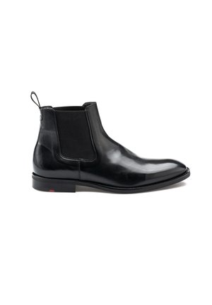 Bottines Chelsea en cuir noir avec des panneaux élastiques sur les côtés, une languette à l'arrière et une semelle en caoutchouc fine. Fini lisse et design à bout pointu.