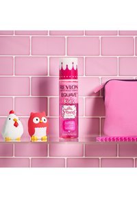 Revlon Equave Kids utredningsbalsam i en rosa flaske, hylle med hvite kylling- og røde ugleleker, rosa pose mot rosa flislagt bakgrunn.