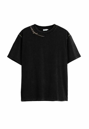 Mustvalge lühikeste varrukatega T-särk ümara kaelusega, beeži dekoratiivse õmblusega krae lähedal ja varrukatel, esikülg sile, lõdvestunud istuvus.