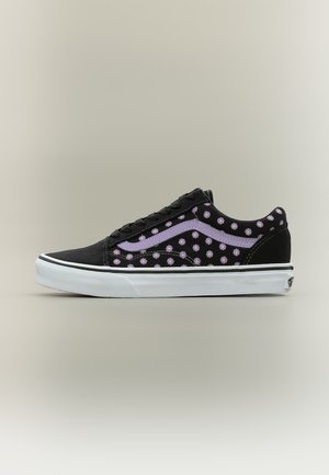 Baskets basses noires avec semelle blanche, décorées d'un motif floral violet et d'une bande violette le long du côté.