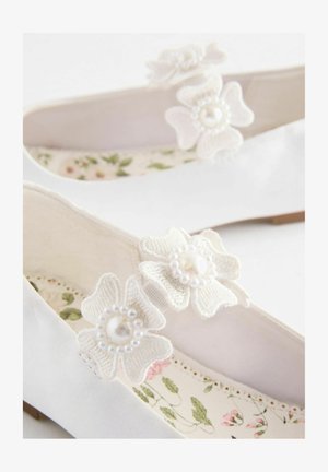 Bijele balerinke s cvjetnim čipkastim aplikacijama sa bisernim središtima, mekom tkaninom, teksturiranom unutrašnjosti s cvjetnim uzorkom i niskim potplatom.