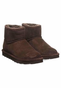 Bottines en daim marron avec une douce doublure en fourrure, bout rond et semelle en caoutchouc plate. Elles présentent un col de hauteur moyenne et des accents de couture minimes.
