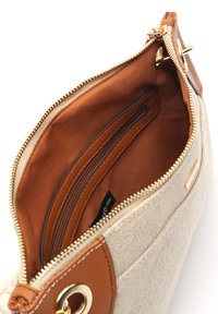 Beige tygväska med bruna läderdetaljer och guldfärgad dragkedja. Insidan har en brun foder och två dragkedjefickor för organisering.