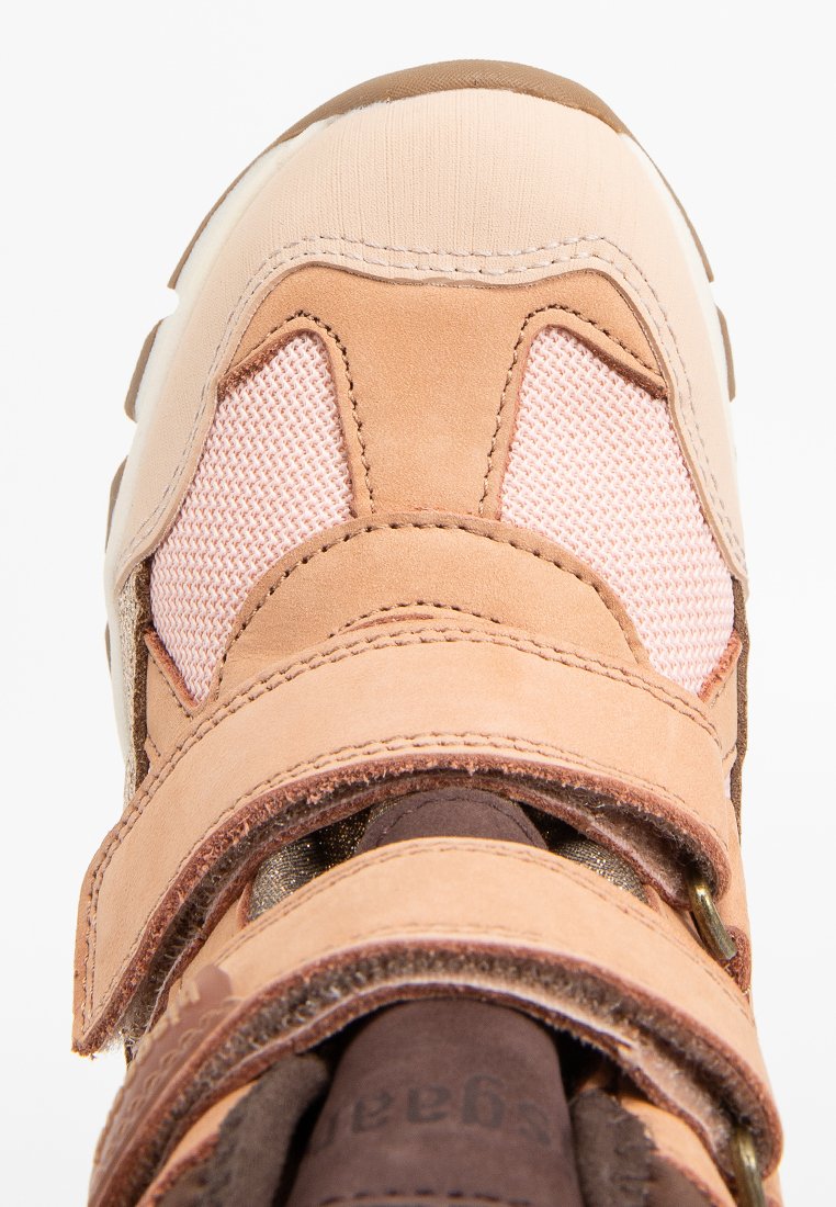 Sandfarbene und rosa Sneakers, die eine Kombination aus Wildleder und Mesh zeigen, mit Klettverschlüssen und kontrastierenden Texturen im Obermaterial.