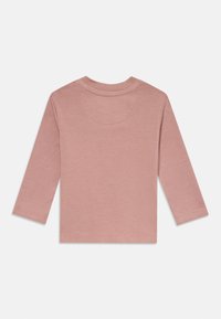 Ilgi piedurkņu bāla rozā bērnu krekls ar apaļu kakla izgriezumu, redzams no aizmugures uz baltā fona.