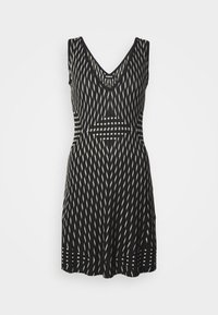 Czarna i biała sukienka w wzory z dekoltem w serek, bez rękawów i zwiewnym dołem. Posiada pionowe i poziome wzory w linie.