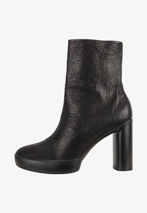 Sort ankelstøvle lavet af tekstureret læder med rund tå, høj blokhæl og platformssål. Glat overflade uden synligt hardware.