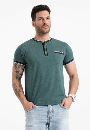 Grünes Polohemd mit kurzen Ärmeln, Knopfleiste, kontrastierendem Kragen und Ärmelsäumen sowie einer kleinen Brusttasche mit horizontalen Streifen.