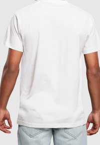 Bílý bavlněný tričko s krátkým rukávem a kulatým výstřihem, s hladkou texturou a rovný střih ve spodní části.