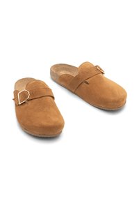 Brązowe zamszowe klapki slip-on z zaokrąglonym noskiem i regulowanym paskiem z metalowym klamrą. Teksturowana wkładka oraz gumowa podeszwa zapewniająca przyczepność.