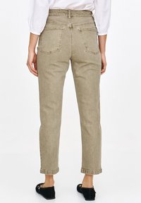 Beżowe dżinsy z wysokim stanem, proste nogawki, pięć kieszeni i podwinięte mankiety. Widok z tyłu ukazuje dwie kieszenie tylne. Miękka tekstura denimu.
