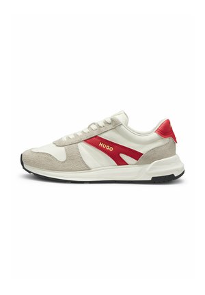 Białe i beżowe zamszowe sneakersy z czerwonymi akcentami, czarną podeszwą i logo "HUGO" z boku.