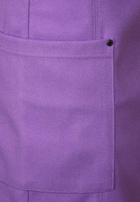 Violetti kangas, jossa on sileä pinta, sisältää sivutaskun, joka on kiinnitetty mustalla painonapilla. Saumadetailsit ovat näkyvissä reunoilla.