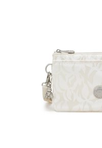 Borsa in tessuto bianco con motivo floreale, zip argentata, logo circolare e dettaglio di charm in metallo. Design compatto con attacco per tracolla.