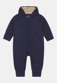 Marineblauwe gewatteerde simpele overall met een capuchon, voorzien van een zachte, beige fleecevoering en elastische manchetten. Voorkant met ritssluiting en reliëf logo-detaillering.