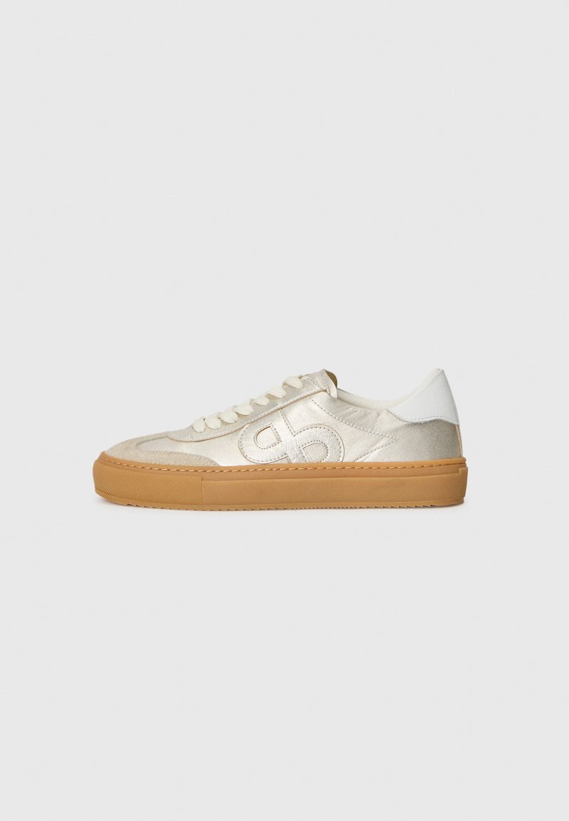 Schnür-Sneaker mit einem Obermaterial aus leicht goldenem Stoff, tanfarbener Gummisohle und weißen Fersenakzenten. Mit gesticktem Logo an der Seite.