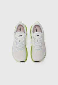 White running shoes with a textured mesh upper, light green sole, and blue and white laces. Features branding on the tongue and sides.