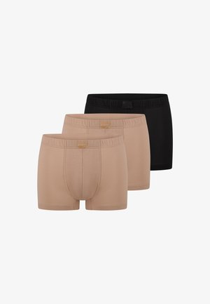 Tre par mænds boxershorts i beige og sort, arrangeret side om side med elastiske linninger og frontkontursyninger.