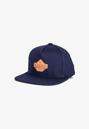 Cappello piatto di colore blu navy realizzato in tessuto testurizzato, con una toppa in pelle marrone con il logo "BLACKSKIES". Costruzione a sei pannelli.