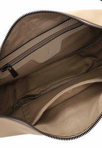 Beežist tõmbluku kotike, millel on sile väline pind, sisemise tõmbluku taskuga ja pehme voodriga. Nähtav must tõmblukk ja õmblusdetailid.