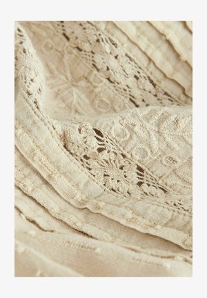 Leinenstoff in sanftem Beige mit aufwendigen Spitzenakzenten und strukturierten Streifen. Enthält zarte Blumenmuster und erhabene Akzente.