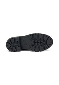 Suela de zapato de goma negra con un patrón de relieve resistente, con indentaciones angulares y un área central suave. Marcada con la talla 37.