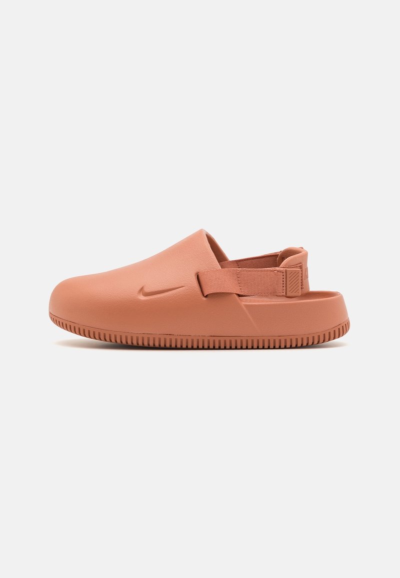 Sandale slip-on à bout fermé de couleur terracotta avec une semelle texturée et une sangle ajustable au talon, avec un petit logo embossé sur le côté.