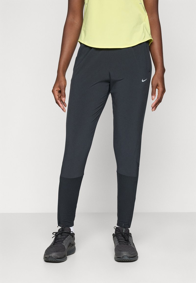 Schwarze Sporthosen mit tailliertem Design, aus leichtem Material gefertigt. Verfügt über ein kleines weißes Logo und kontrastierendes Material in der Nähe der Knöchel.