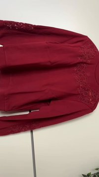 Camisa vermelha de manga longa com detalhes bordados florais nos ombros e mangas, feita de um tecido suave e com um corte descontraído.