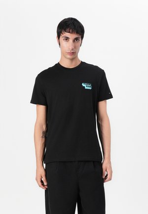 T-shirt en coton noir avec un petit logo "Tommy Jeans" turquoise sur la poitrine. Design classique à col rond avec des manches courtes.