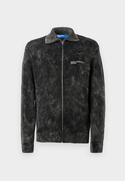 Veste en velours côtelé noir avec une texture côtelée, col montant et fermeture éclair à l'avant ; présente le logo 'Karl Lagerfeld Jeans' sur la poitrine.