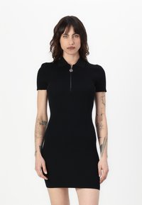 Black short-sleeved dress with a zippered collar, ribbed texture, fitted shape, and subtle silver hardware detail at the zipper.