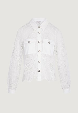 Camicia bianca in pizzo a maniche lunghe con motivi floreali, bottoni d'argento sul davanti e due tasche sul petto con bottone.