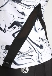 Black and white athletic shirt featuring a swirling marble pattern, with mesh accents on the sides for breathability. Logo visible at base.