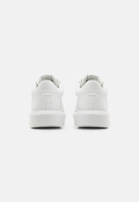 Weiße Sneakers mit einer glatten, glänzenden Lederoberfläche, runder Form und einem dezenten Logoakzent an der Ferse. Niedrig geschnittenes Design mit Schnürung.