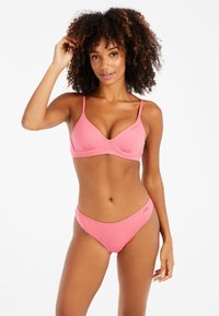 Pink ribbeliger Bikini mit einem dreieckigen Bralette-Oberteil und passenden tief geschnittenen Unterteilen. Der Stoff hat eine glatte Textur mit minimaler Verzierung.