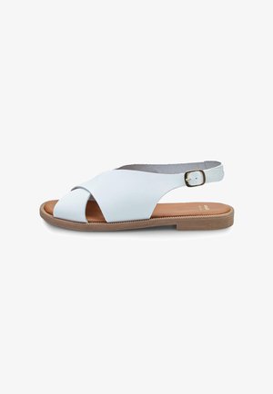 Sandal cu toc din piele albă, cu un design încrucișat, vârful deschis și talpă din lemn. Caracteristici includ o cataramă mică ajustabilă pe brățara de gleznă.