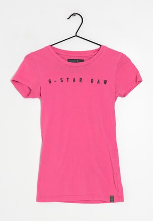 Vaaleanpunainen puuvillapaita lyhyillä hihoilla, pyöreällä kaula-aukolla ja mustalla "G-STAR RAW" -tekstillä etupuolella. Koko pieni -merkintä näkyvissä.