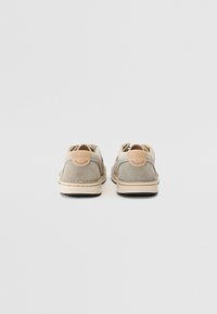 Gray suede shoes with a light beige leather accent at the heel, flat soles, and visible stitching along the edges.