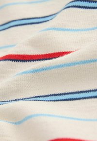 Tessuto in maglia morbida con strisce orizzontali azzurro chiaro, blu navy e rosso su sfondo crema, mostrato in dettaglio ravvicinato.