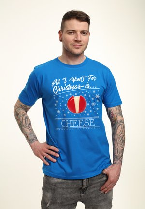 Blå kortærmet t-shirt med hvid festlig tekst og en rød cirkel med en ostewedge. Stoffet ser glat og let ud.
