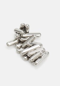 Srebrna metalna skulptura, ki prikazuje povezanih, podolgovatih oblik z gladkimi površinami in zaobljenimi konci, kar ustvarja tekočo obliko v kontrastu z belo ozadjem.
