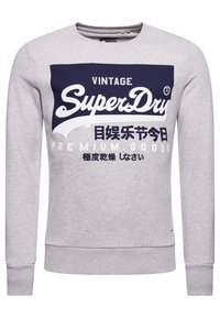 Sudadera gris de mezcla de algodón, con un estampado gráfico en azul marino que muestra "SuperDry" y texto. Puños y dobladillo acanalados.